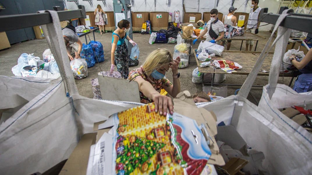 Люди сортируют мусор на станции переработки, созданной проектом «Україна без сміття» («Украина без мусора»)