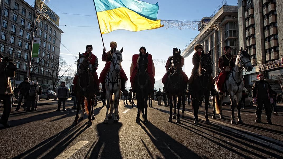 Люди в казацких нарядах на лошадях охраняют Майдан со стороны Европейской площади под отстроенными баррикадами в Киеве, 14 декабря 2013 года
