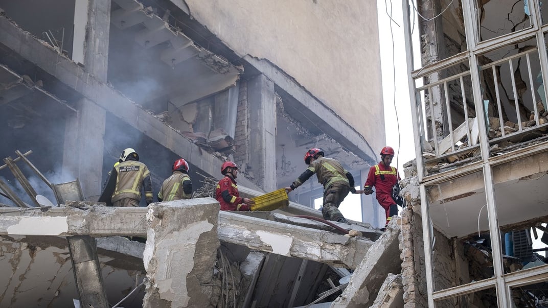 Іранські пожежники на місці зруйнованого житлового будинку внаслідок атаки Ізраїлю на Тегеран, 13 червня 2025 року