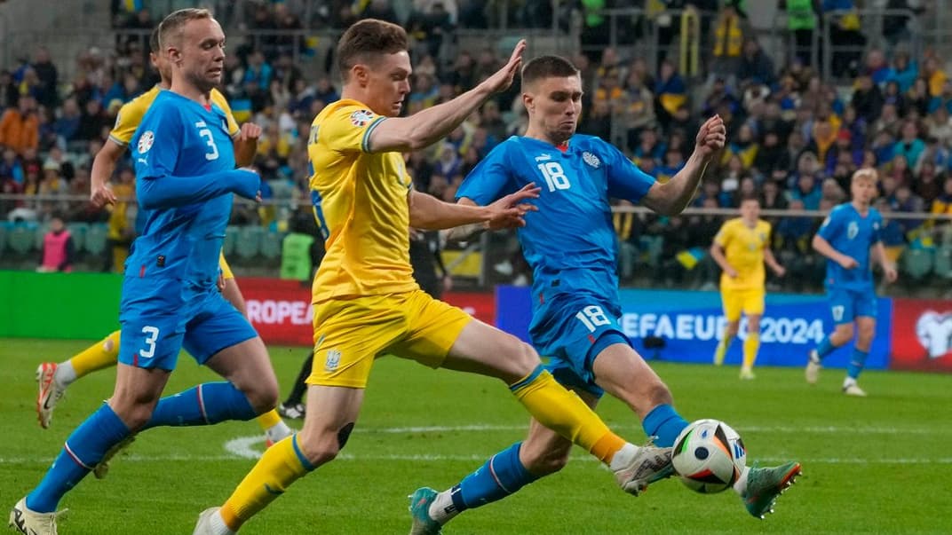 Український півзахисник Віктор Циганков (у центрі) в поєдинку за м’яч з ісландським гравцем Даніелем Гретарссоном, 26 березня 2024 року