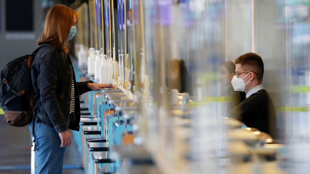 Пасажирка стоїть на паспортному контролі, очікуючи пропуску