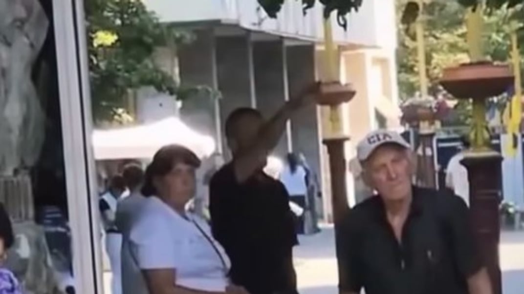 Чоловік, що показує  жест, схожий на нацистський салют, під час хвилини мовчання