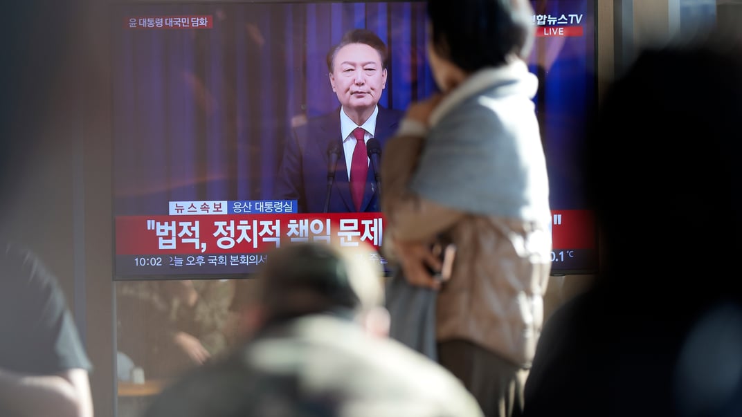 Жителі Південної Кореї дивляться звернення президента Юн Сок Йоля на залізничному вокзалі в Сеулі, 7 грудня 2024 року