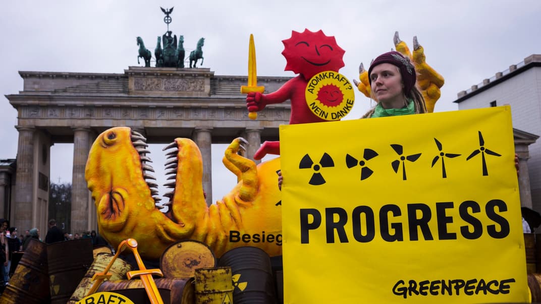Активистка Greenpeace позирует с плакатом перед Бранденбургскими воротами во время митинга по случаю прекращения ядерной кампании в Германии, Берлин, 15 апреля 2023 года