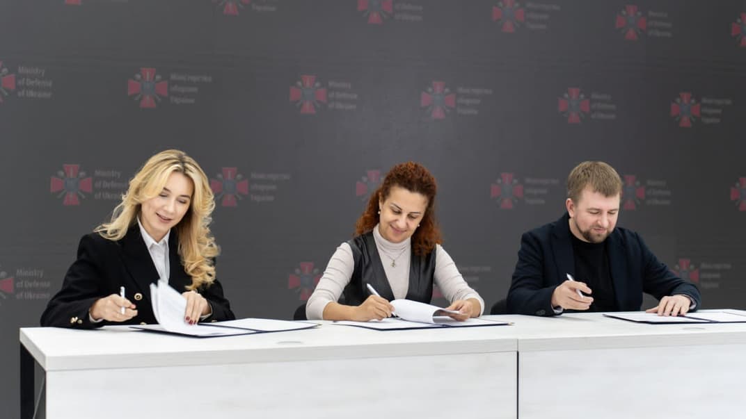 Заступниця міністра оборони Наталія Калмикова, директорка Державного центру зайнятості Юлія Жовтяк та директор з інновацій robota.ua Сергій Лозко підписують документ про співпрацю