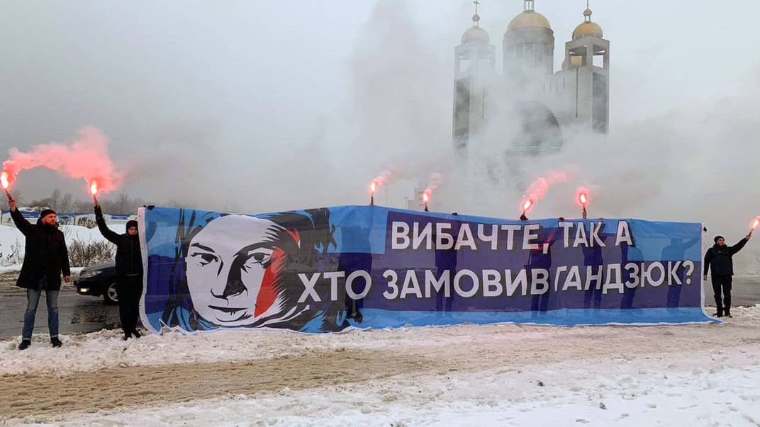 Акція біля місця проведення форуму «Від Крут до Брюсселя. Ми йдемо своїм шляхом», на якому виступив Петро Порошенко, Київ, 29 січня 2019 року. Учасники тримають плакат із написом «Вибачте, так а хто замовив Гандзюк?»