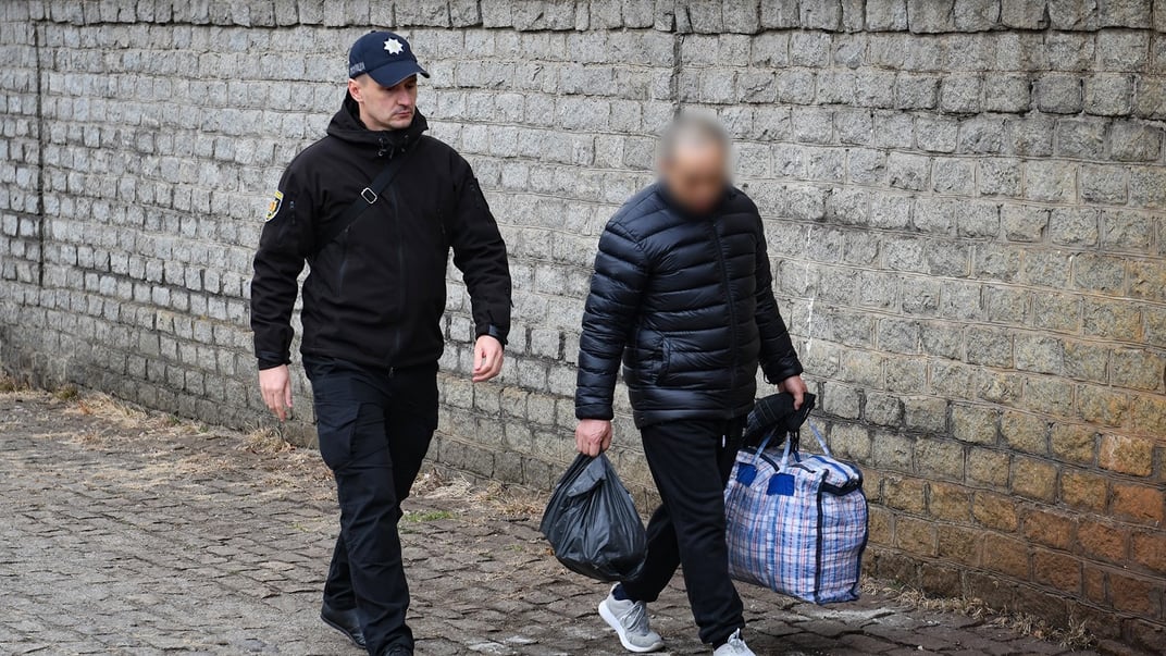 Китайский ученый, отбывший наказание за шпионаж, покидает исправительную колонию в сопровождении полицейского