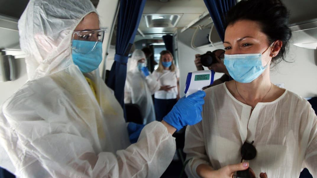 Международный аэропорт «Борисполь» готовится к открытию и восстановлению пассажирских полетов, Киев, 13 июня 2020 года. Стюардесса измеряет температуру воображаемой пассажирке