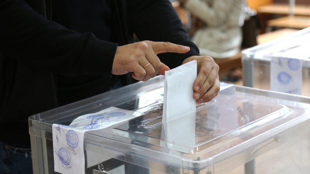 Ілюстративне фото. Виборець кидає бюлетень в урну для голосування під час чергових місцевих виборів, на одній з виборчих дільниць, в селище Коцюбинське, 25 жовтня 2020 року