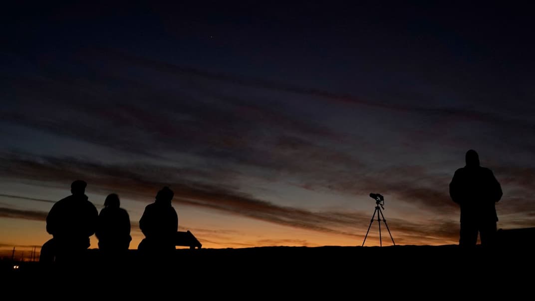 Люди наблюдают за сближением Юпитера и Сатурна в городе Эдгертон, штат Канзас. США, 21 декабря 2020 года