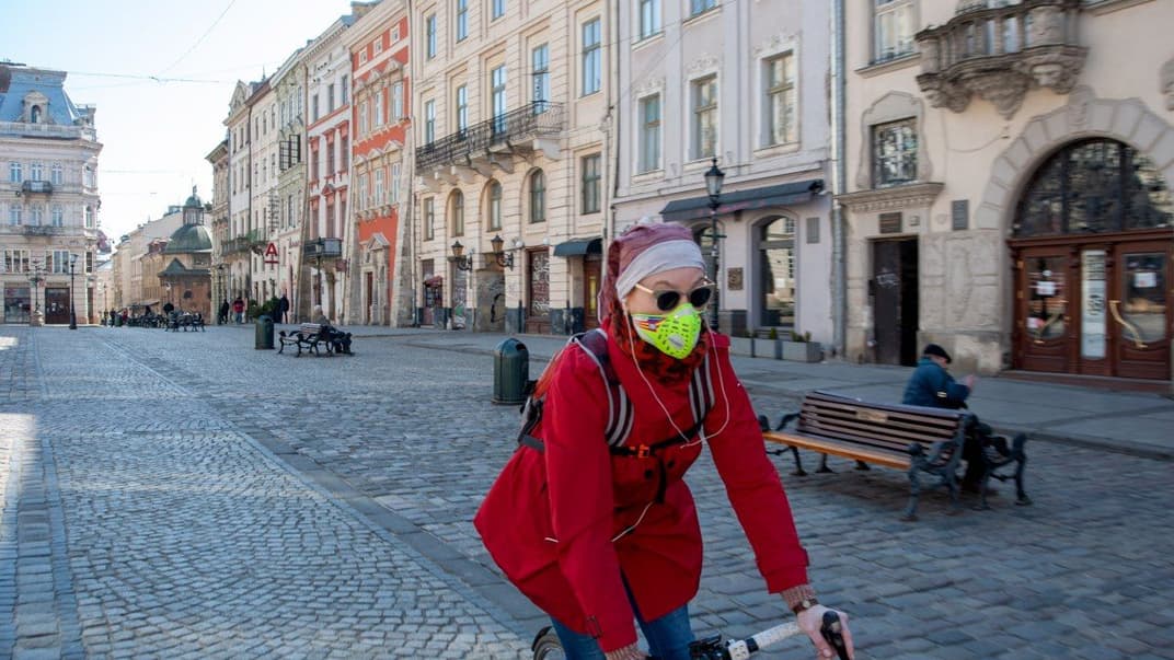 Жінка на велосипеді їде майже безлюдною туристичною вулицею під час карантину у Львові, 2 квітня 2020 року