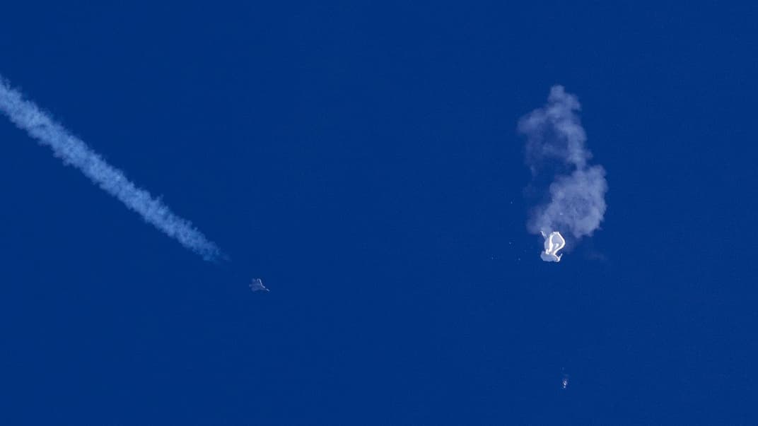 Винищувач летить біля залишків  повітряної кулі після того, як по ній вдарили ракетою над Атлантичним океаном, 4 лютого 2023 року