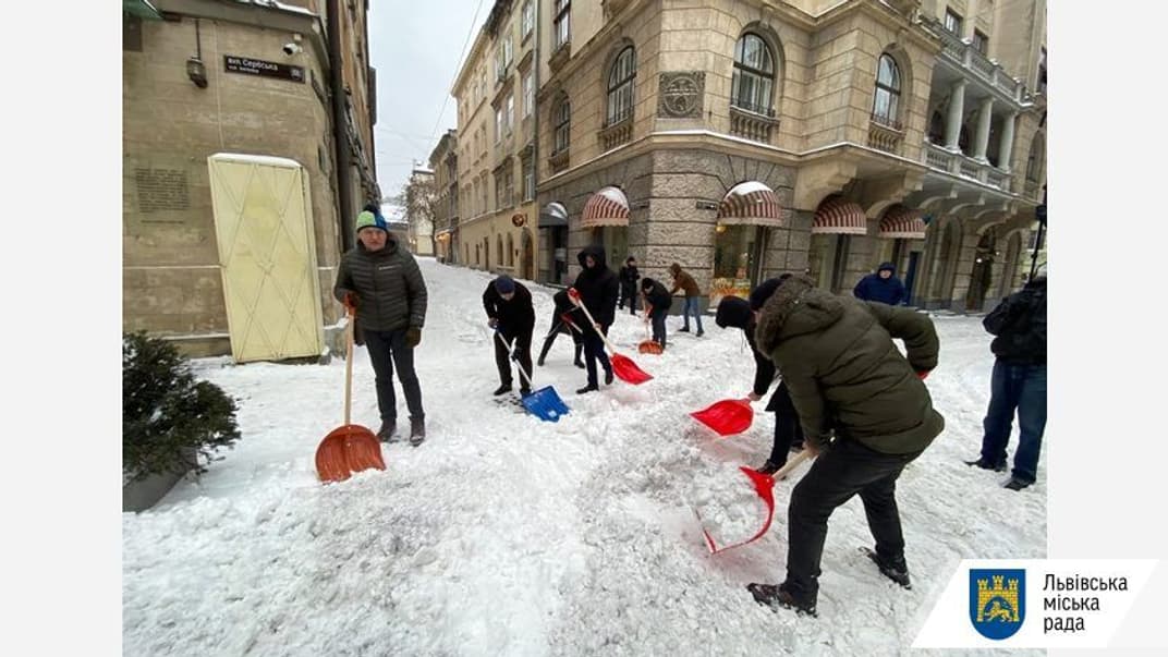 Мер Львова Андрій Садовий (ліворуч) разом з працівниками мерії прибирає сніг, Львів, 8 лютого 2021 року