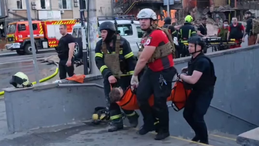 Спасатели несут раненого в Киеве, 6 июня 2025 года
