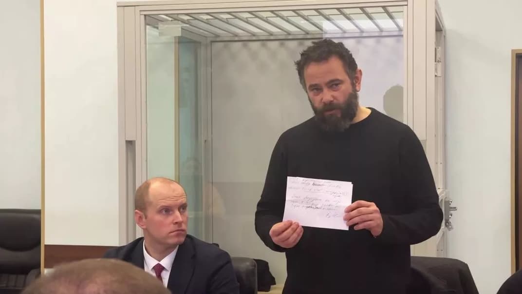 Олександр Дубінський у залі суду показує медвисновок, що у нього два зламані ребра, 7 грудня 2023 року