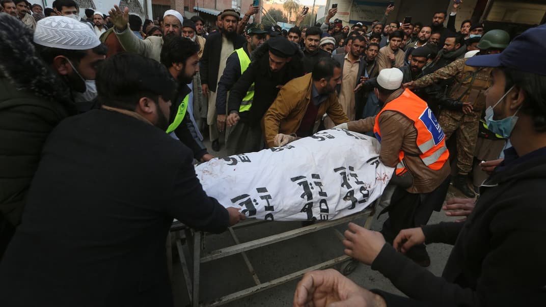 Люди несут тело своего родственника, погибшего во время теракта смертника в мечети, Пешавар, Пакистан, 30 января 2023 года