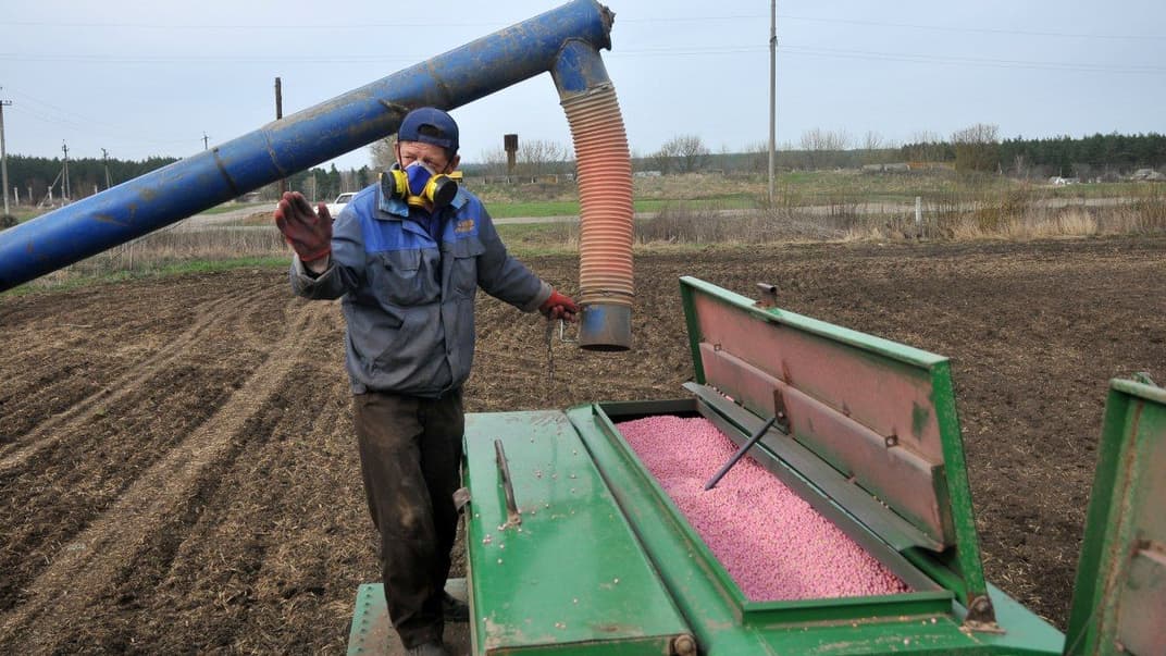 Робітник агрофірми завантажує насіння в сівалку під час посівної кампанії в Харківській області, 18 квітня 2018 року