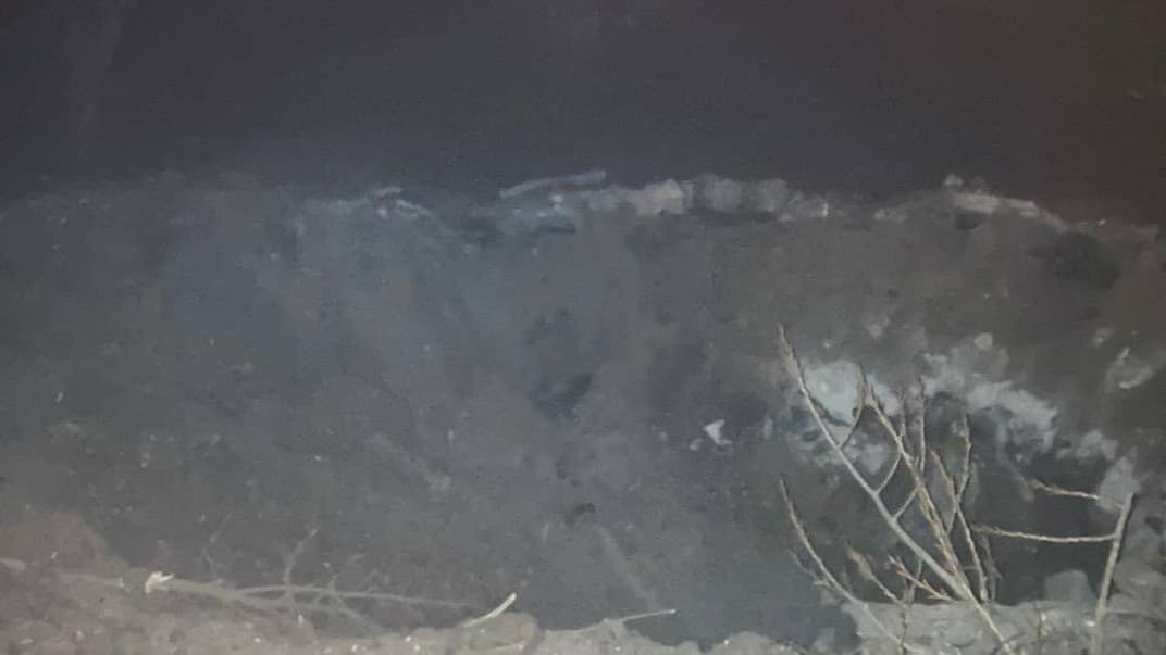 Яма, появившаяся после российского обстрела окраины Запорожья