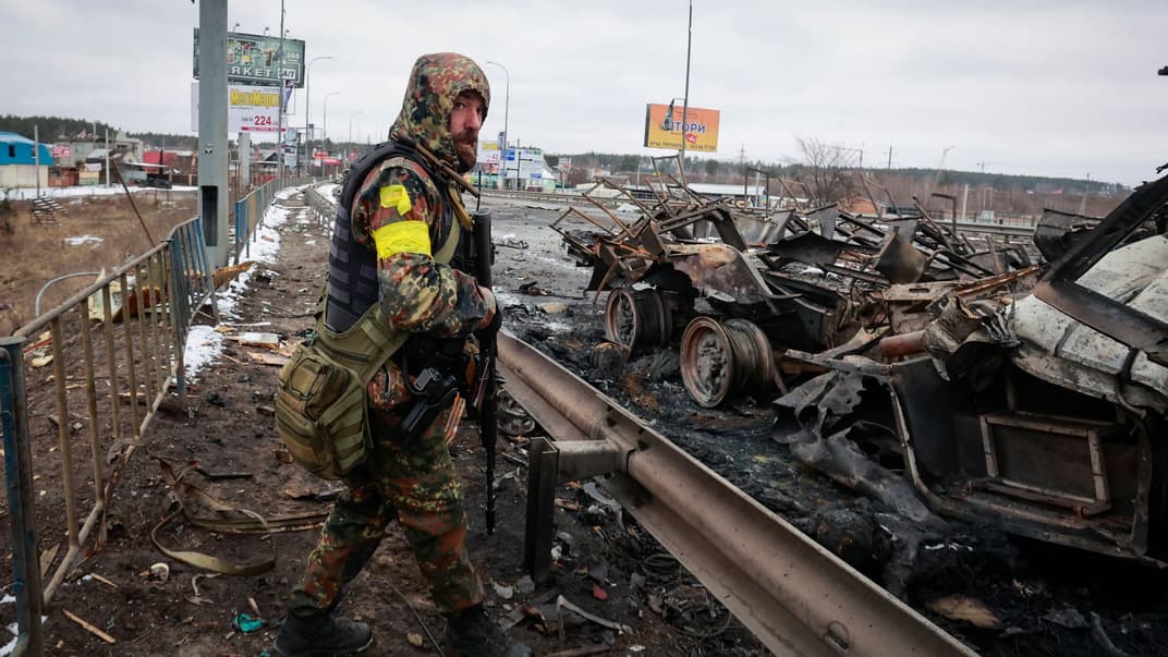 Озброєний український чоловік стоїть біля залишків російської техніки, Буча під Києвом, 1 березня 2022 року