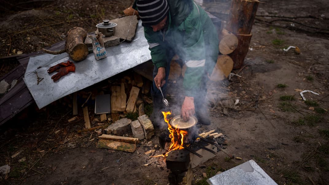 63-річний Володимир Лук’янович готує вечерю біля свого будинку, який зруйнували росіяни, В Ірпіні на околиці Києва, 20 квітня 2022 року