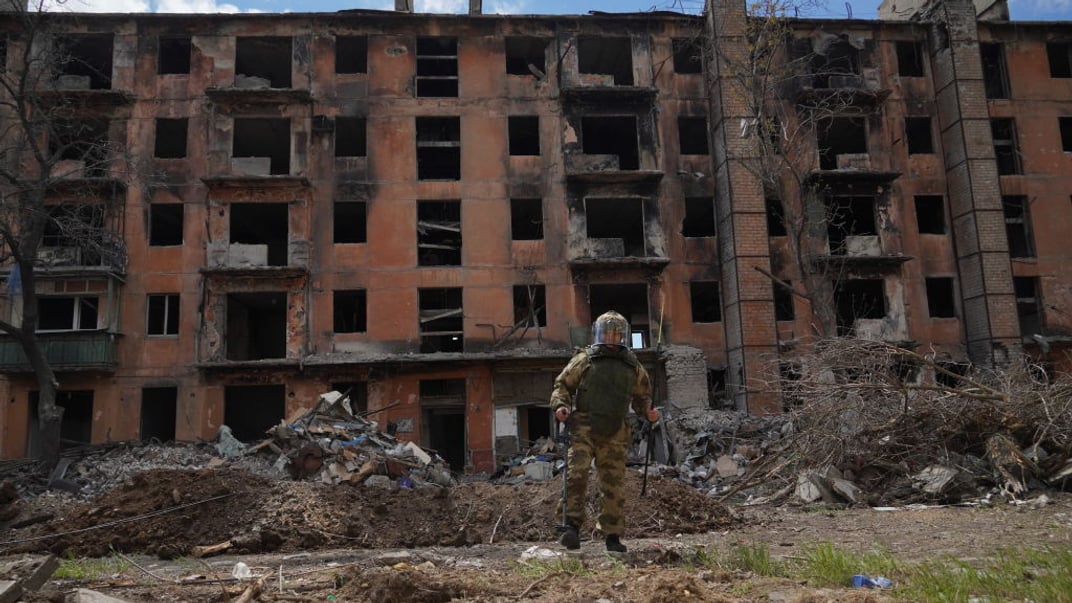 российский военный разминирует территорию вблизи уничтоженного армией рф дома в Мариуполе, апрель 2024 года