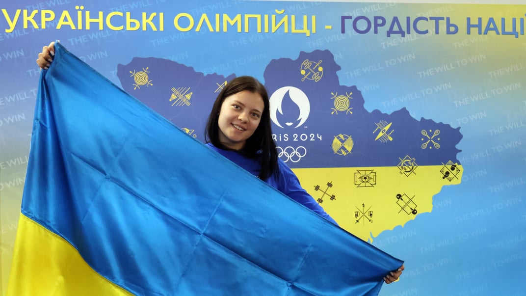 Софія Лискун тримає національний прапор під час церемонії зустрічі після повернення з літніх Олімпійських ігор 2024 у Парижі