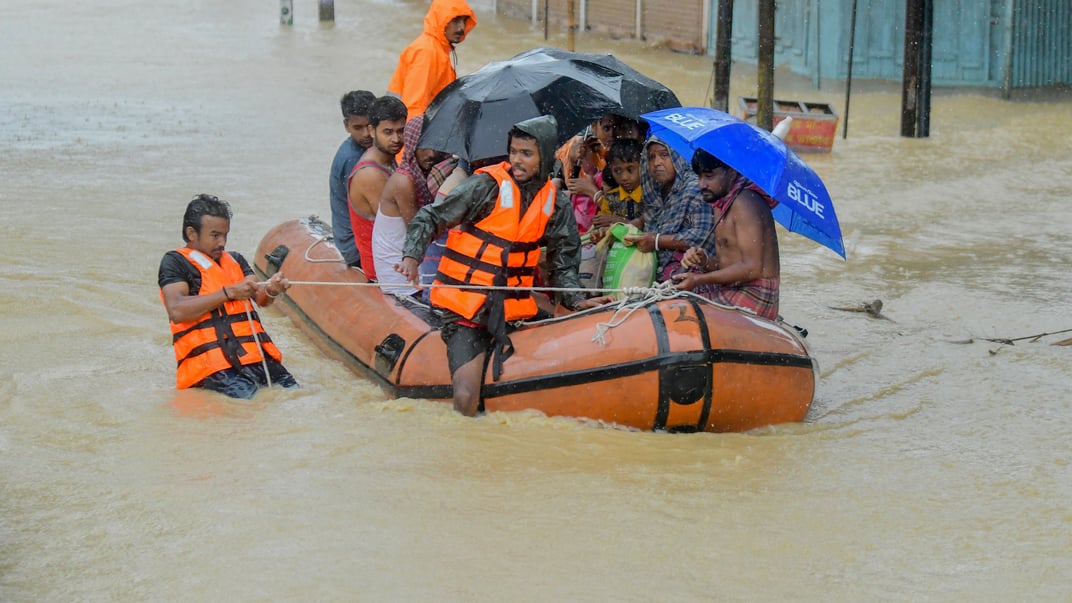 Рятувальники перевозять постраждалих від повені в Індії