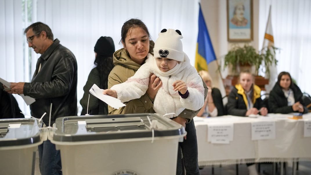 Ілюстративне фото. Жінка тримає дитину під час голосування в Кишиневі, 20 жовтня 2024 року