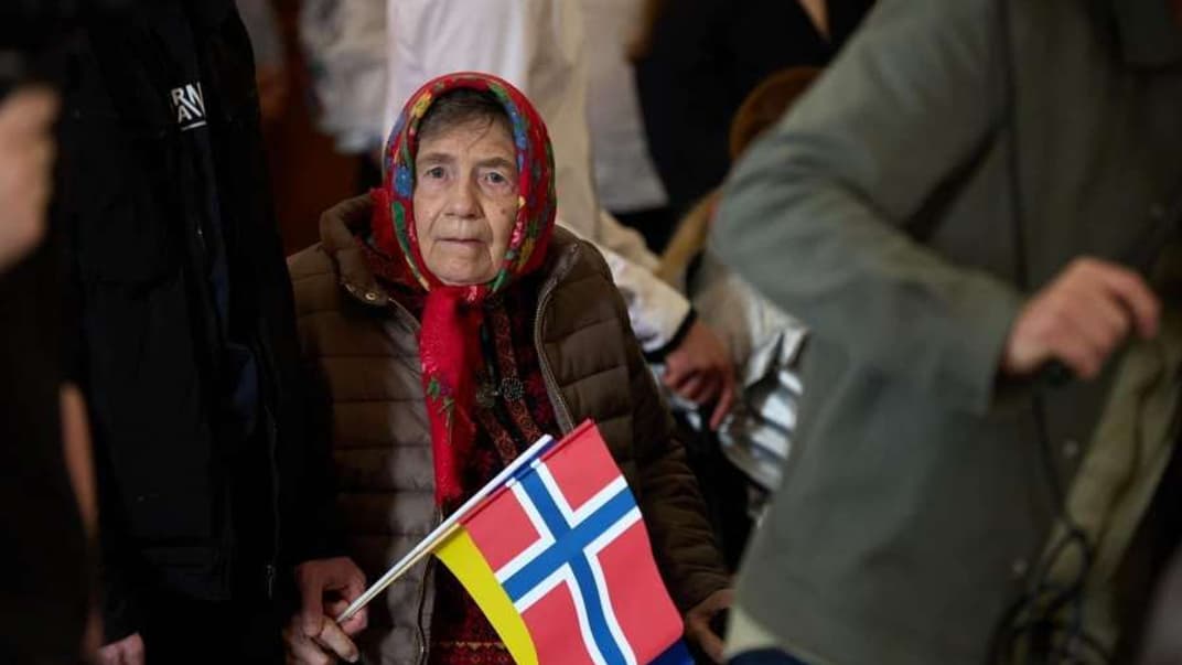 Жінка, яка виїхала з України через війну до Норвегії, тримає прапори обох країн під час візиту голови Верховної Ради Руслана Стефанчука в Норвегію, 16 травня 2023 року