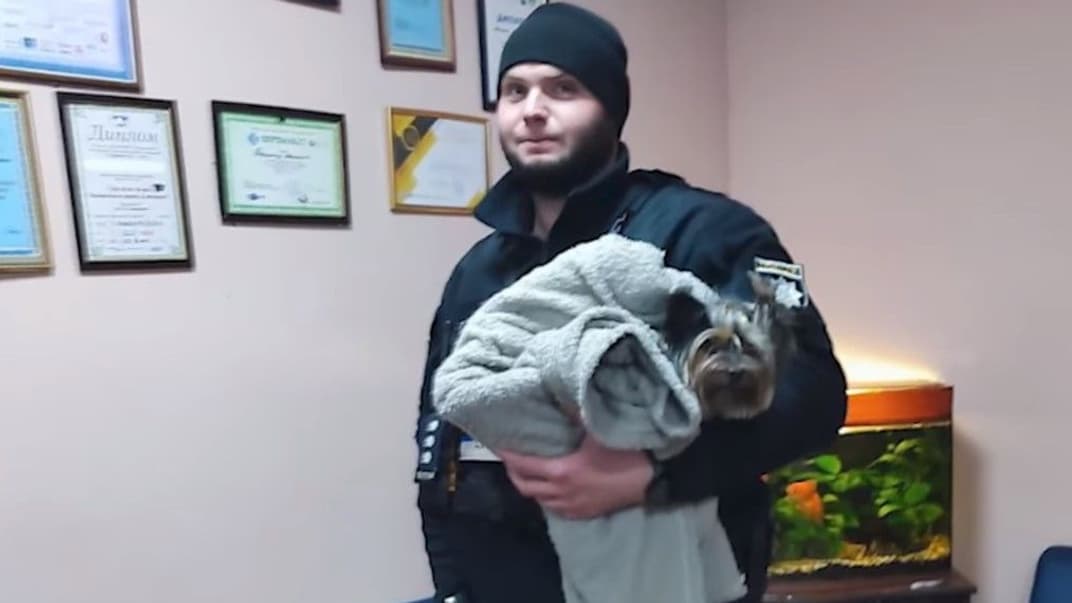 Поліціянт тримає врятованого собаку