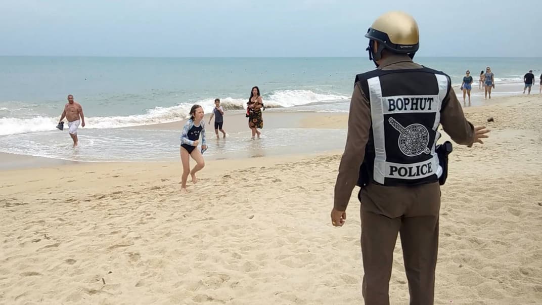 Офіцер поліції попереджає туристів про заборону купатиися через наближення негоди на пляжі острова Самуї, провінції Сурат Тані, Таїланд, 3 січня 2019 року