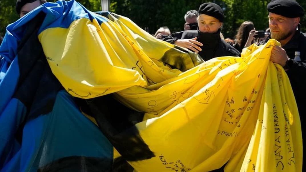 Поліція прибирає прапор України з боку радянського військового меморіалу в районі Тіргартен у Берліні, Німеччина, неділя, 8 травня 2022 року