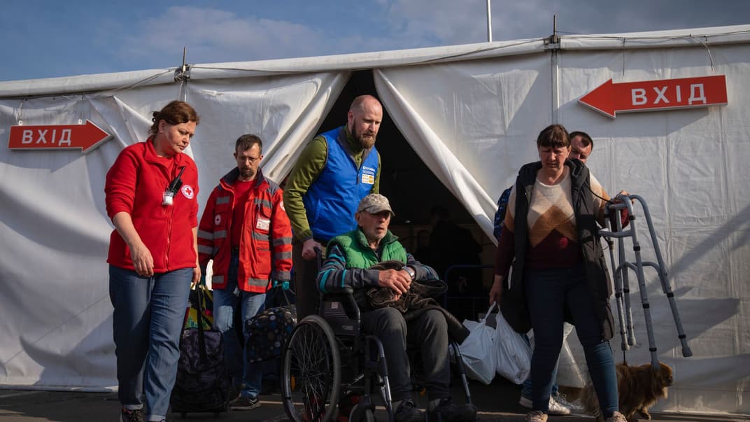 Волонтери допомагають чоловікові після його прибуття з Маріуполя у центр для переміщених осіб у Запоріжжі, 3 травня 2022 року