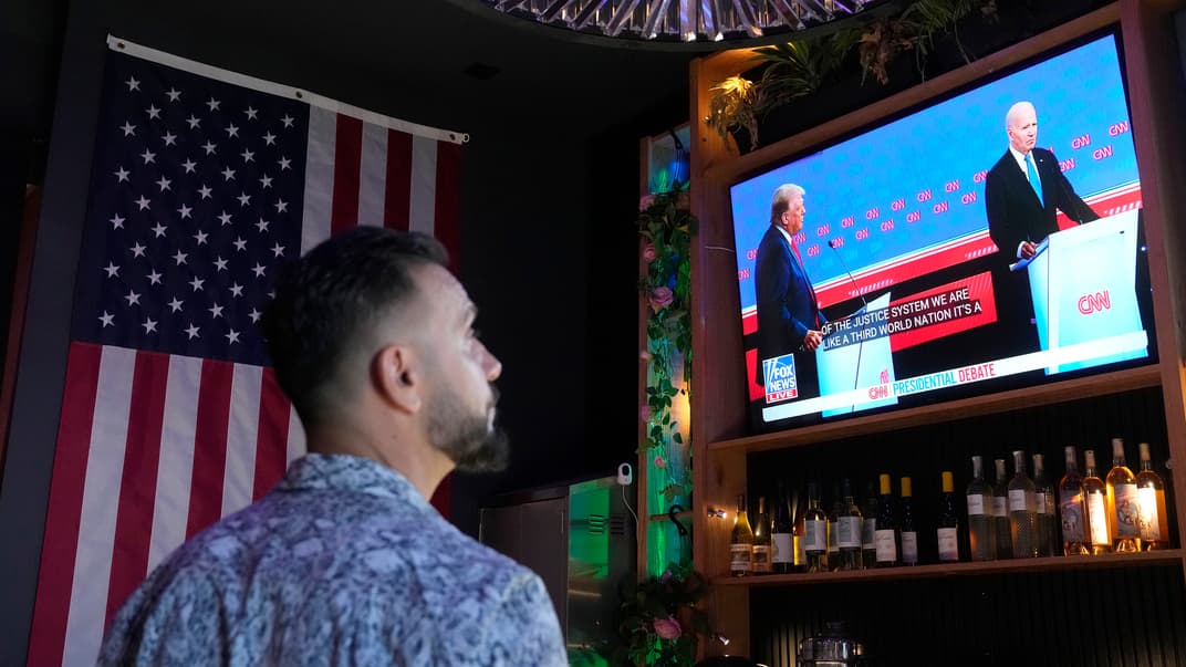 Зритель наблюдает за дебатами президента Джо Байдена, кандидата в президенты от Демократической партии и бывшего президента Дональда Трампа в Скоттсдейле, штат Аризона, 27 июня 2024 года