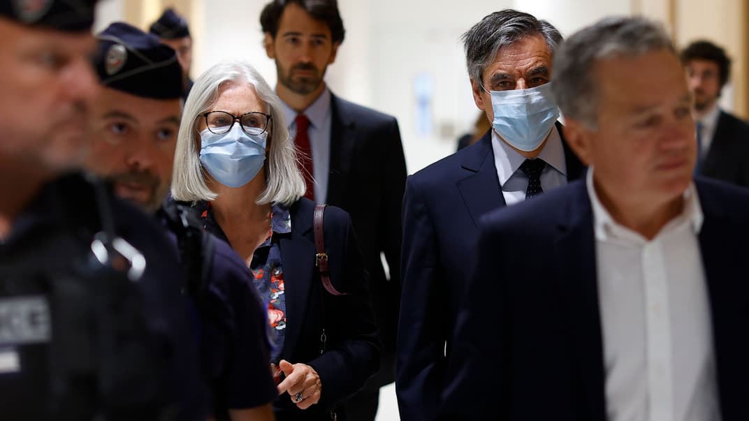 Колишній прем'єр-міністр Франції Франсуа Фійон (справа на задньому тлі) та його дружина Пенелопі прибувають до судової зали, аби почути вирок у їхній справі про розкрадання державних коштів, Париж, Франція, 29 червня 2020 року