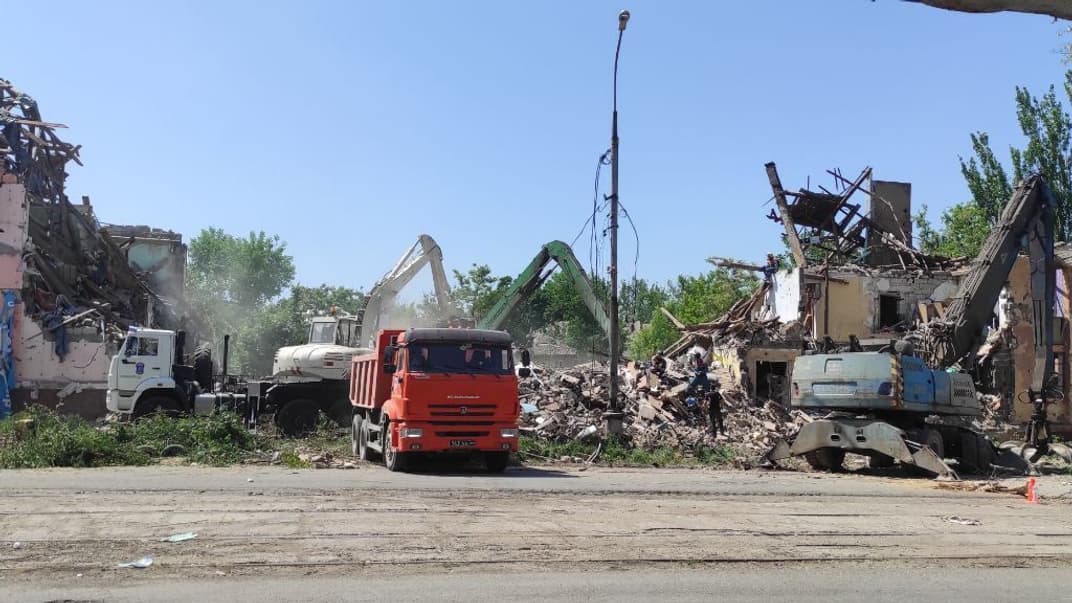 Оккупанты разбирают завалы дома, который сами же расстреляли в Мариуполе