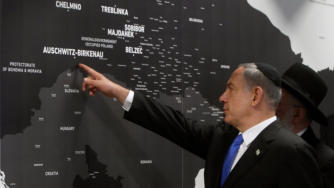 Премьер-министр Израиля Беньямин Нетаньяху указывает на карту, показывающую места гибели евреев во время Холокоста на открытии нового павильона в бывшем нацистском лагере смерти Аушвиц в Освенциме, июнь 2013 года