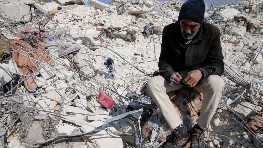 Чоловік сидить серед уламків зруйнованої будівлі в місті Ель-Атареб, Сирія, 12 лютого 2023 року