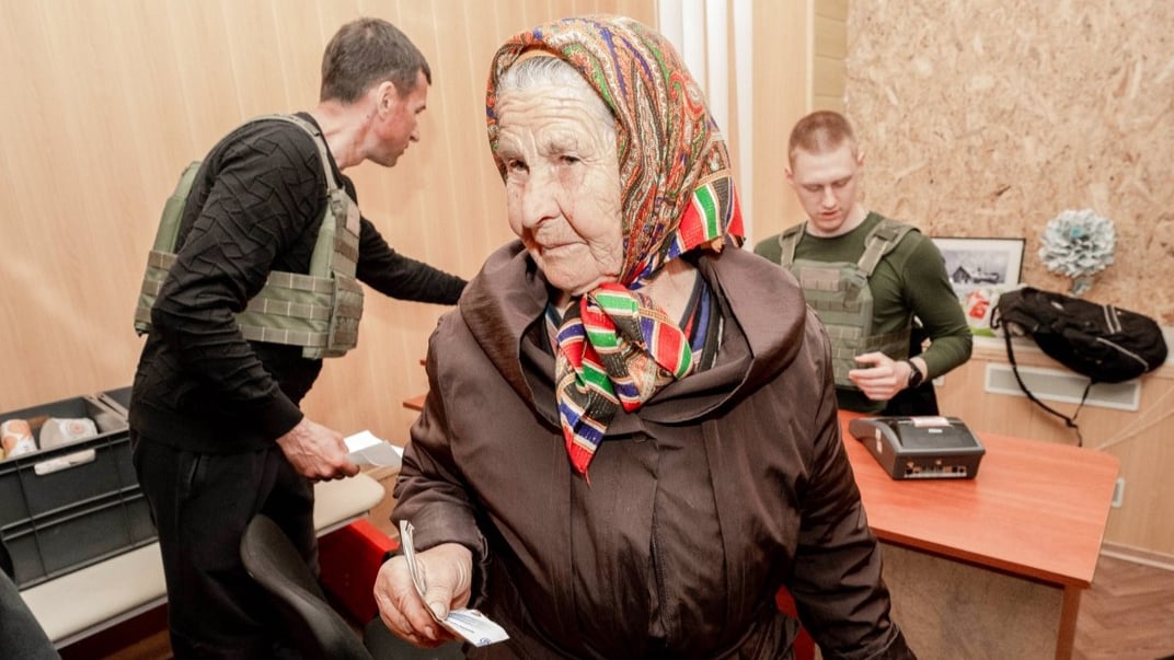 Ілюстративне фото. Жителька Харківщини отримує пенсію у приміщенні школи в селі Лук’янці, травень 2023 року