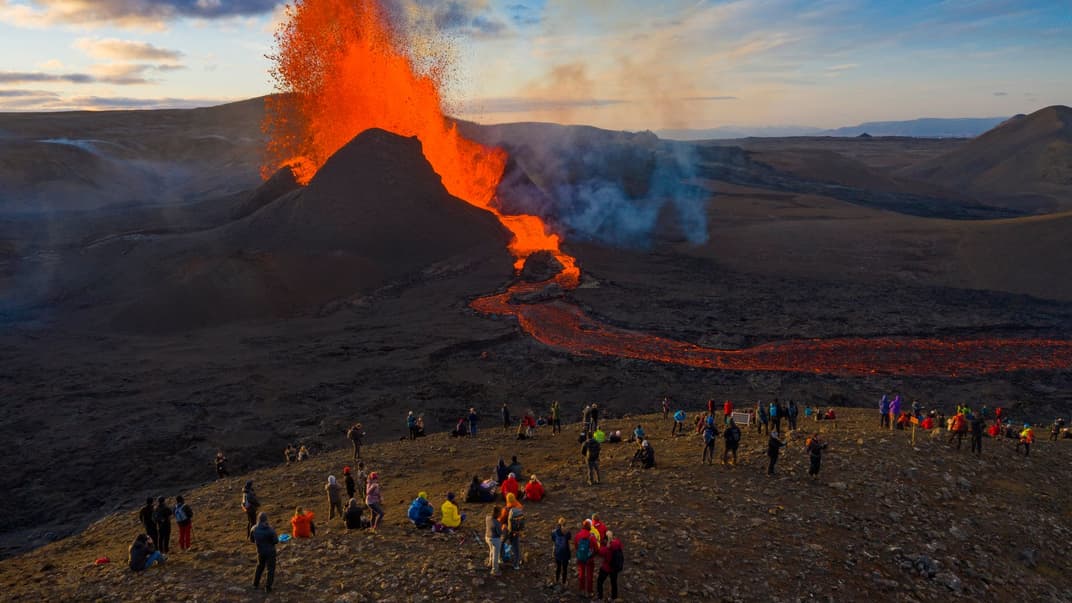 Люди спостерігають, як лава витікає з вулкана Фаградальсф'ядль на південному заході Ісландії, 11 травня 2021 року