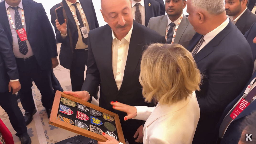 Журналістка Олена Курбанова дарує президентові Азербайджану Ільхаму Алієву шеврони ЗСУ