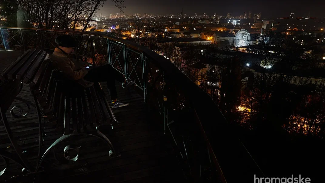 Ілюстративне фото. Чоловік сидить на оглядовому майданчику на Алеї художників на Подолі, 24 жовтня 2022 року