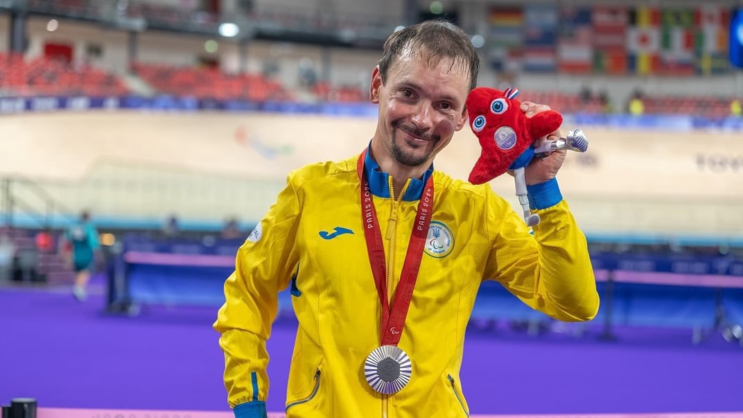 Велоперегонник Єгор Дементьєв позує з талісманом Літніх Олімпійських та Паралімпійських ігор у Парижі Фрігі