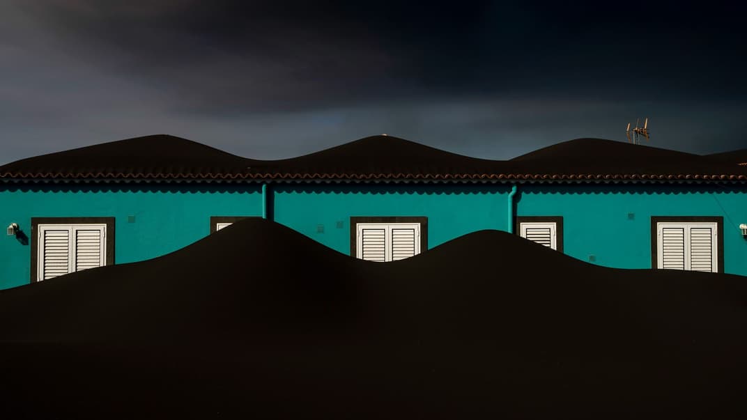 Попіл із вулкана, який продовжує вивергатися, вкриває будинок на Канарському острові Ла-Пальма, Іспанія, 1 листопада 2021 року. За оцінками вчених, вулкан також викинув понад 10 тисяч мільйонів кубічних метрів попелу. Попіл викидається на тисячі метрів у небо, але найважчі, найтовстіші частинки зрештою поступаються силі тяжіння