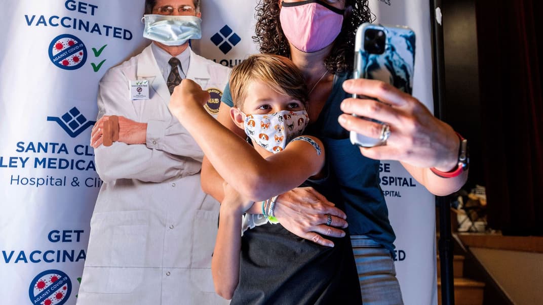 9-річний Фінн Вошберн показує свій слід від вакцини Pfizer-BioNTech, коли його мати, Кейт Елслі, робить селфі, Сан-Хосе, Каліфорнія, 3 листопада 2021 року.