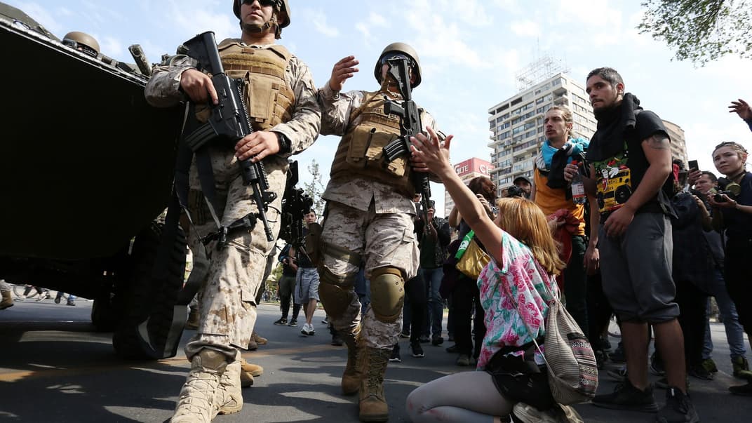 Солдаты пытаются перекрыть движение протестующим в столице Чили Сантьяго.19 октября 2019 года