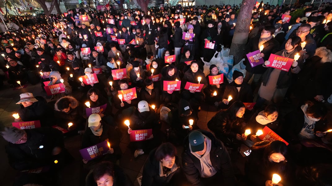 Люди держат свечи во время акции протеста с требованием отставки президента Южной Кореи Юн Сук Еля в Сеуле, 4 декабря 2024 года Люди держат свечи во время акции протеста с требованием отставки президента Южной Кореи Юн Сук Еля в Сеуле, 4 декабря 2024 года