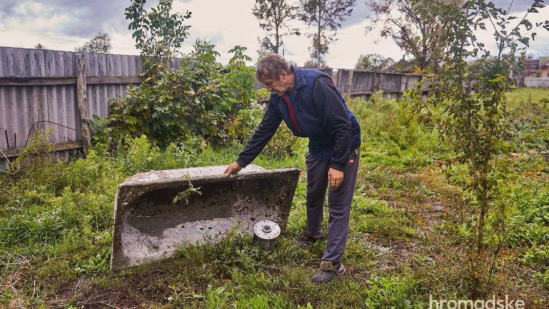 Олександр Тесленко, один із тих, кого катували російські військові, показує ракету від російської РСЗВ, яка влучила у двір його будинку