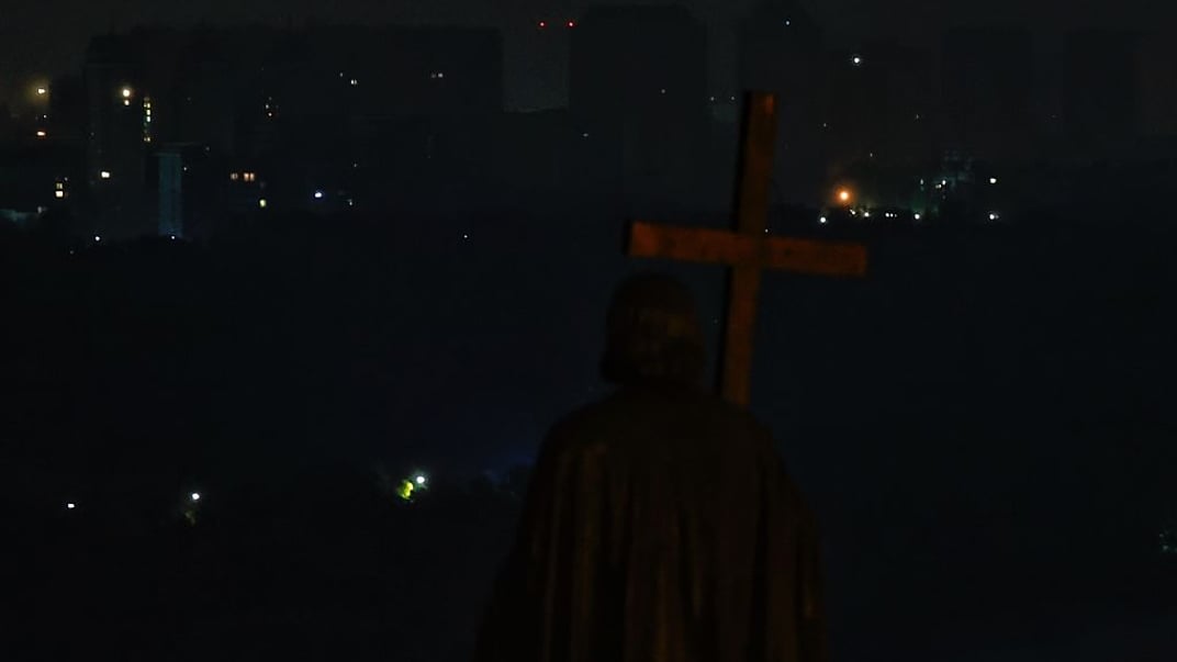 Пам'ятник князю Володимиру на Володимирській горі на тлі житлових районів, які залишаються без електроенергії через російські удари 10 жовтня 2025 року в Києві.