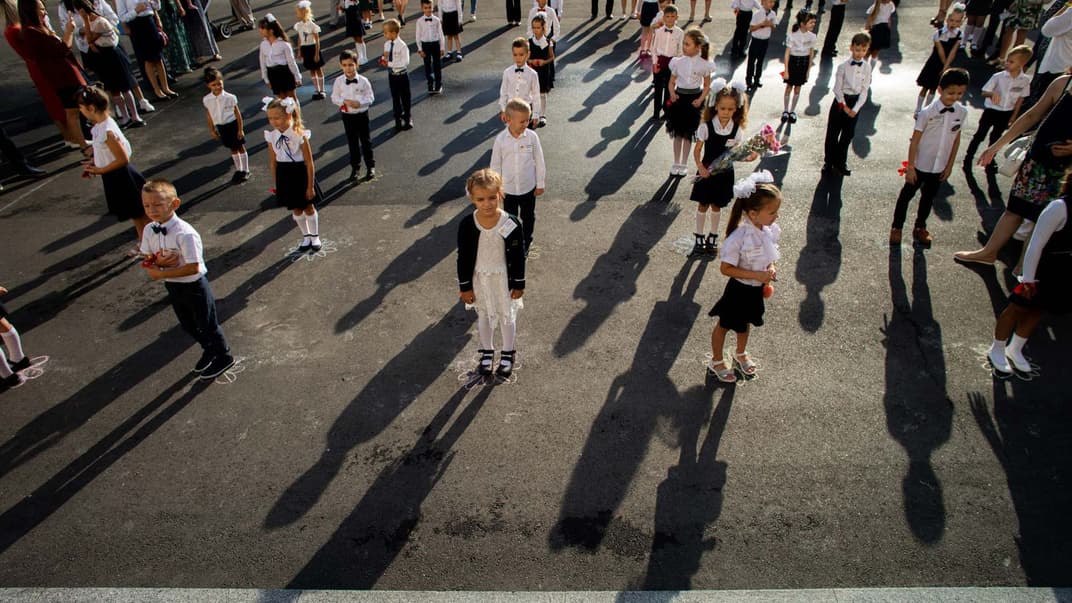 Першокласники стоять на майданчику перед входом до гімназії «Академія» у Святошинському районі Києва